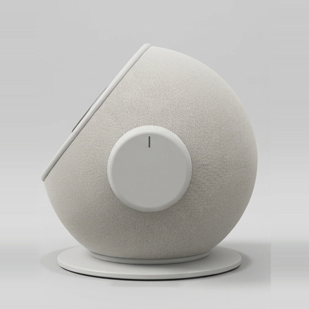 Side view: the volume dial in the middle of the round fabric body, on its base.